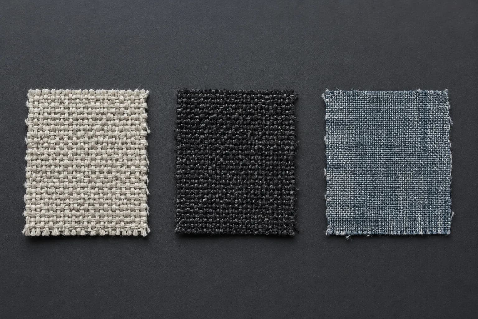 Three cloth swatches laid out in a precise row with even spacing, like samples on an examination bench.