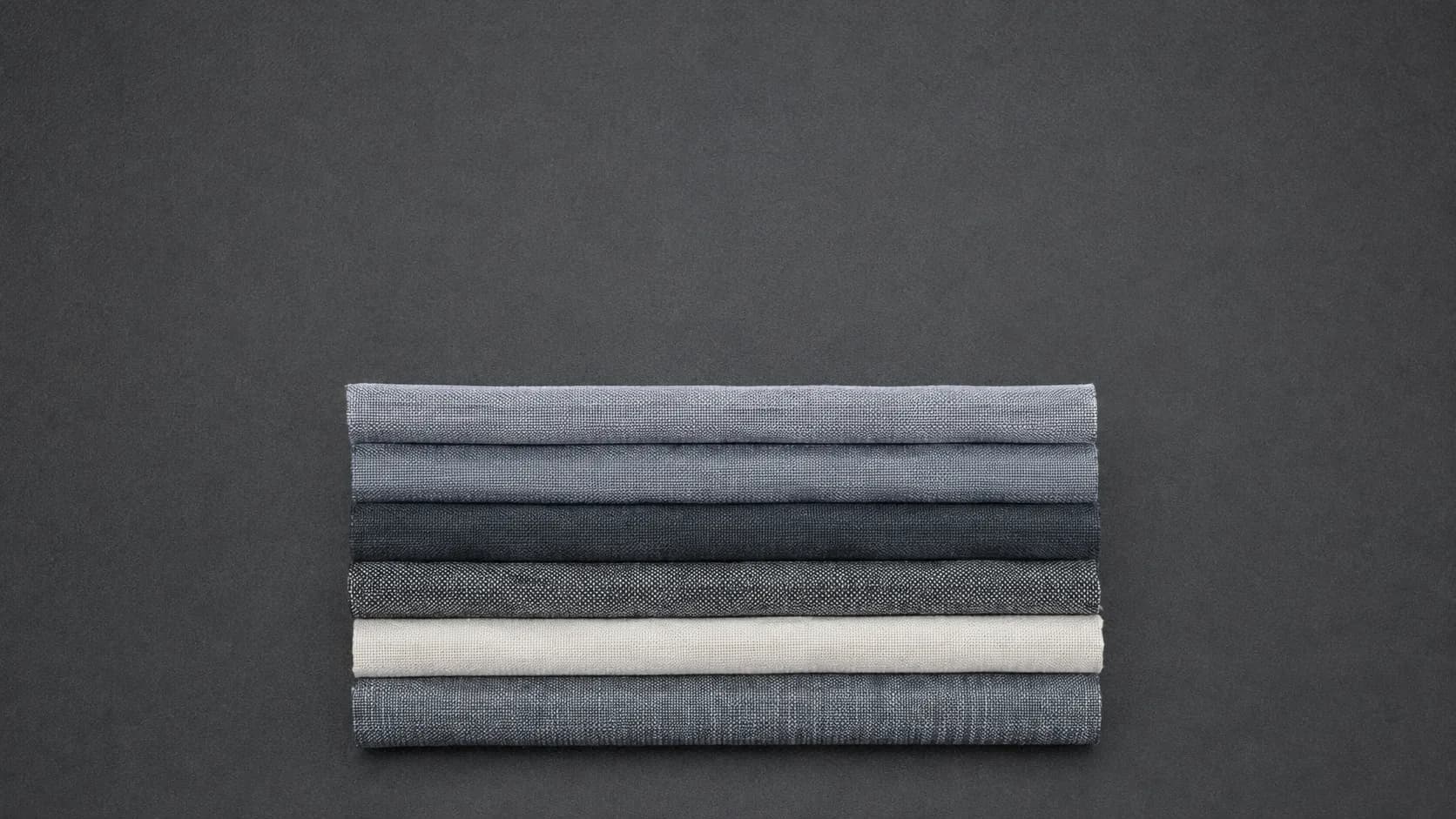 A stack of folded cloth samples with clean parallel edges seen from directly above.