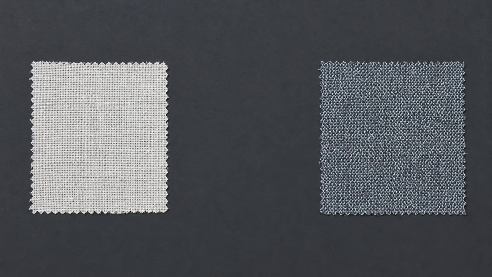 Two small cloth swatches placed a deliberate distance apart on a graphite surface with empty space between them.