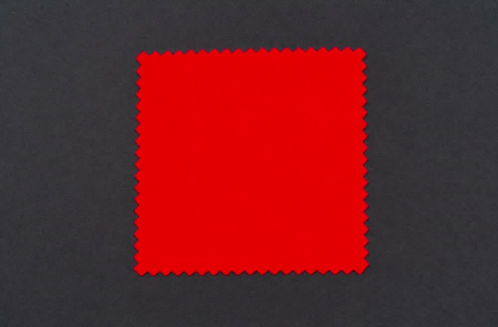 A flat panel of saturated scarlet cloth flattening into a single glowing area as exposure drifts.